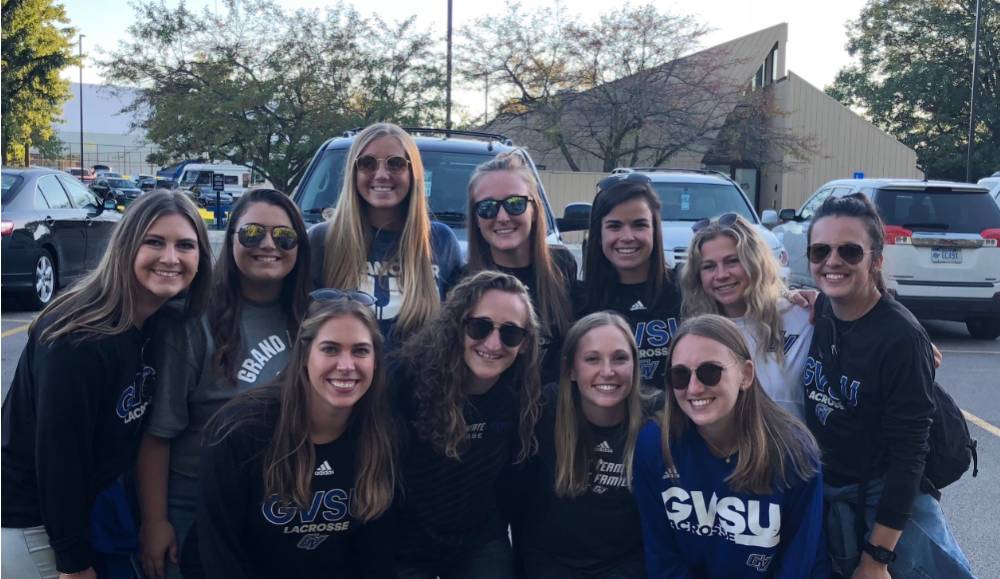 Alumni pose for a photo at the tailgate